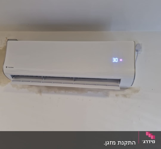 מזגן מותקן על קיר עם תצוגת טמפרטורה
